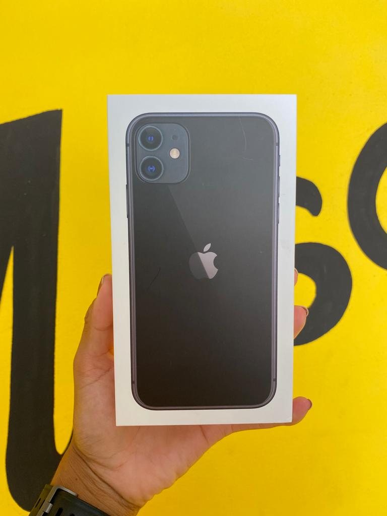 iPhone na caixa em frente à parede amarela da loja